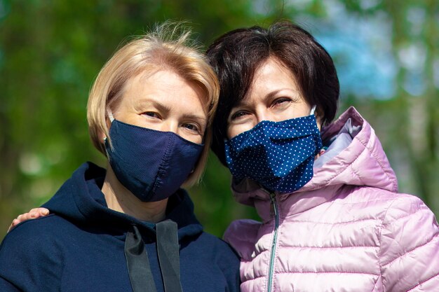 Two happy adult women wearing protective masks