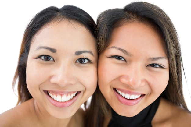 Two happy beautiful sisters smiling at the camera