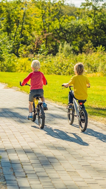 Due ragazzi felici in bicicletta nel formato verticale del parco per la storia mobile di instagram o la dimensione delle storie mobili