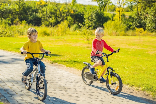 Due ragazzi felici in bicicletta nel parco.