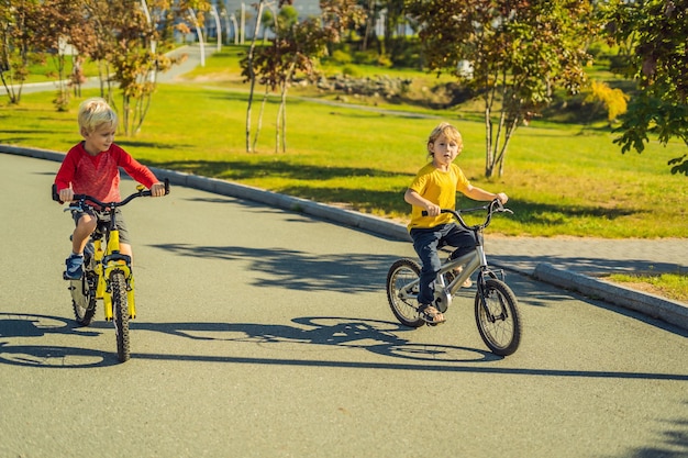 Two happy boys cycling in the park.