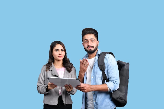 two happy casual students holding white board indian pakistani model