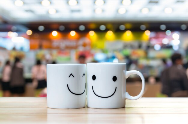 Two happy cups on coffee store blur background