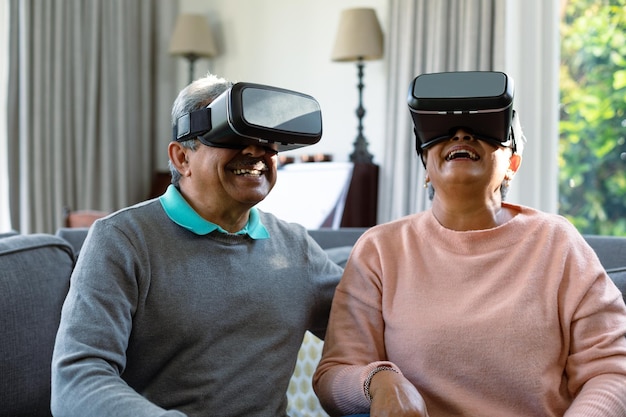 two happy diverse senior couple wearing vr headset and having fun
