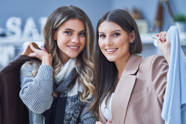 Two happy girls in clothes store during shopping. High quality photo