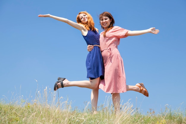 Two happy girls at meadow.