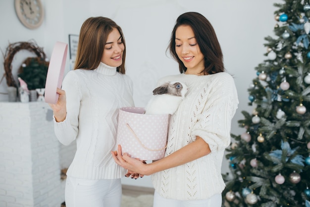 Two happy girls open Christmas gifts.