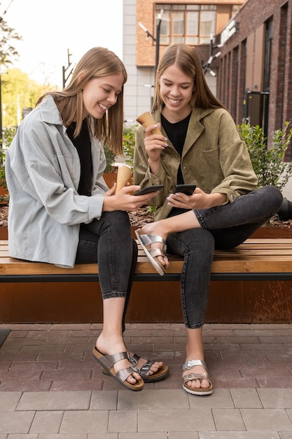 Two happy girls with icecrean watching curious video