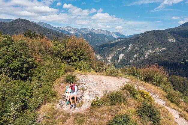 Two happy hiker couple reaching a goal conquering a hill top enjoying in nature