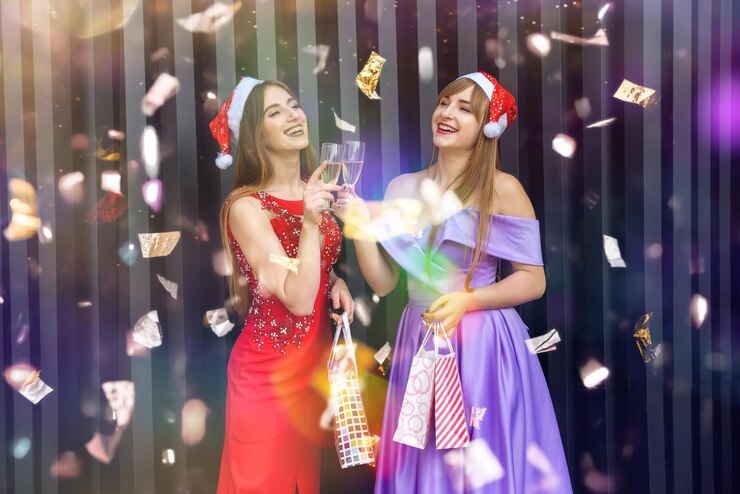 फोटो two happy smiling girls in christmas hats toasting with champagne glasses. new year and christmas celebration