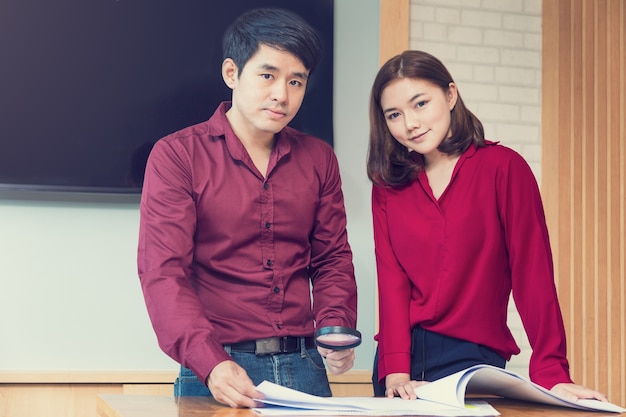 Two happy young executives, male and female, working on a project together