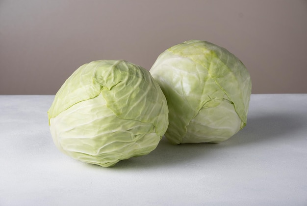 Two heads of white cabbage lie on the surface