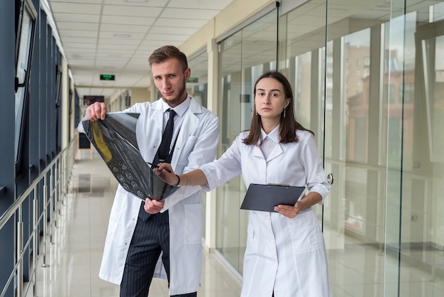 Two healthcare professionals looking at x-ray image,  mri brain  of patient for diagnosis and treatment in hospital