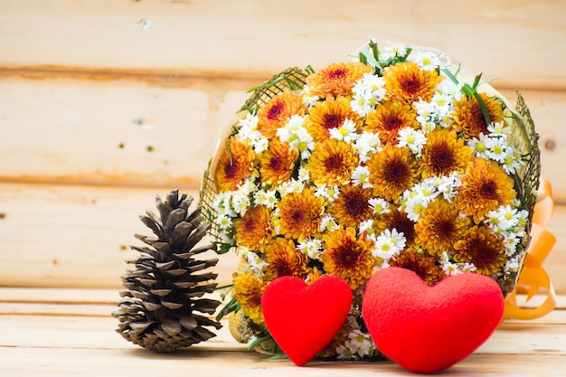 Фото Два сердца и букет цветов на фоне деревянного стола