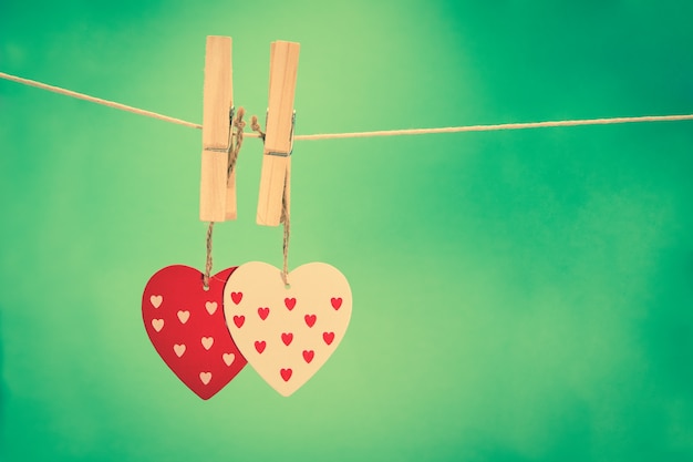 Two heart decorations hanging from pegs on a line