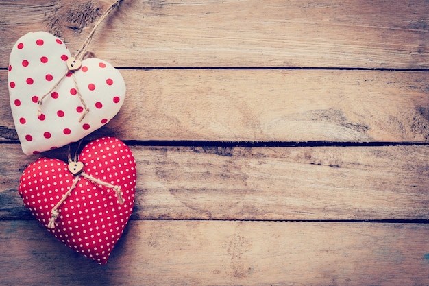 Two heart fabric on wooden table background.