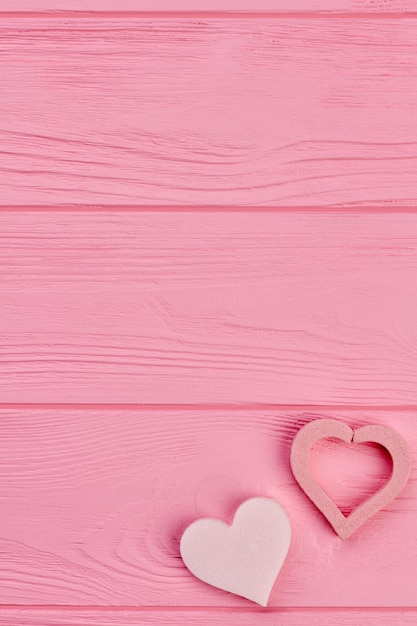 Two hearts and copy space on top. Two pink hearts on pink wooden background, space for text. Happy Valentines Day.