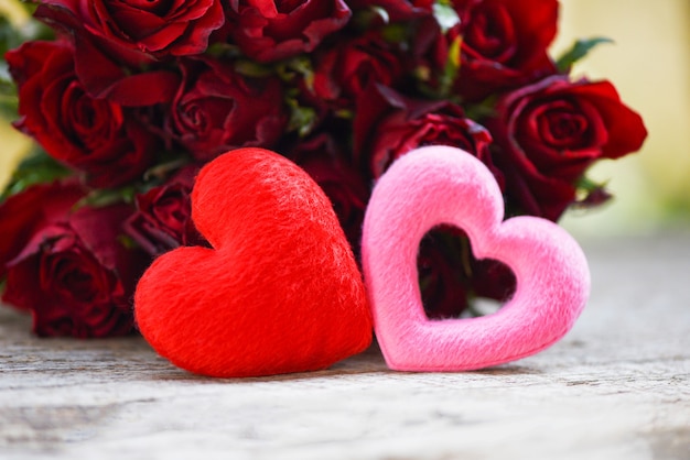 two hearts and roses bouquet on rustic wooden table