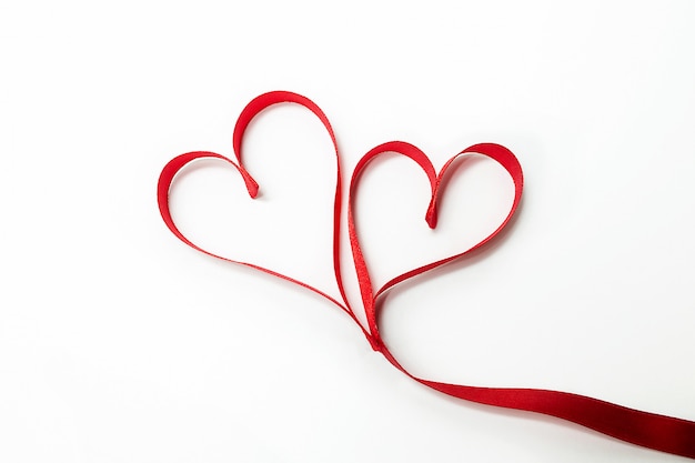 Two hearts tied together made of red ribbon