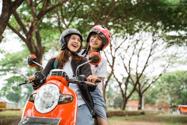 Photo two high school student girls enjoying a motorcycle ride together
