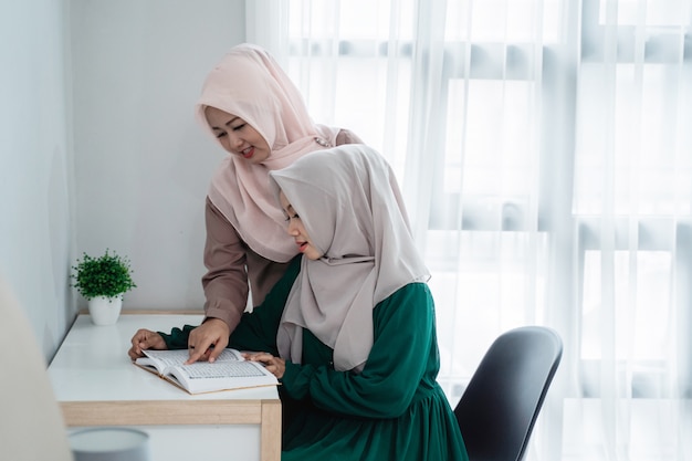 Two hijab women study and reading the holy book of\
al-quran