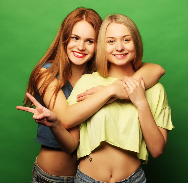 Two hipster girls best friends over green background