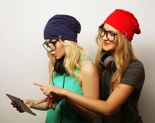 Due amiche hipster usano un tablet digitale