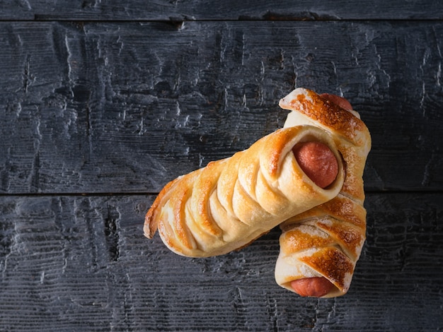 Two homemade sausages on a wooden table. 