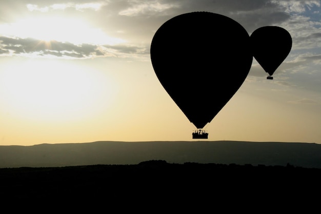 Photo two hot air ballon silhouettes over sunrise