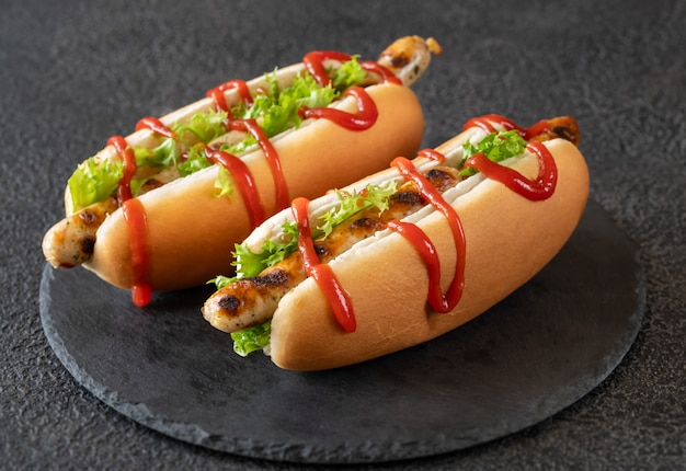 Two hot dogs on stone board