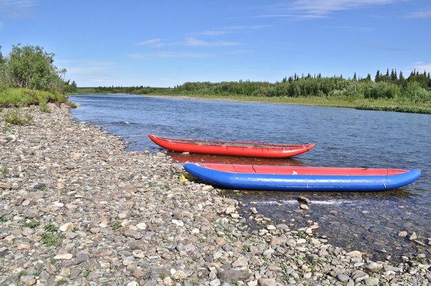 Two inflatable canoes on the shore of North river