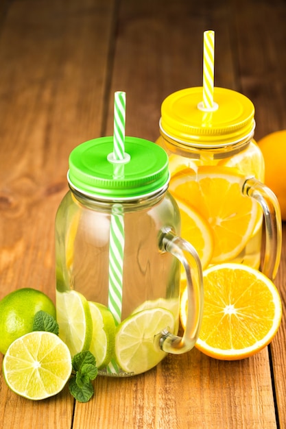 Two jars of detox water with slices of orange and lime