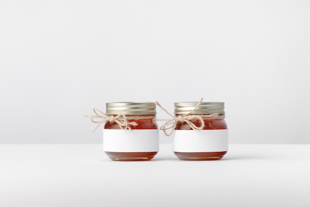 two jars with honey twine and white label