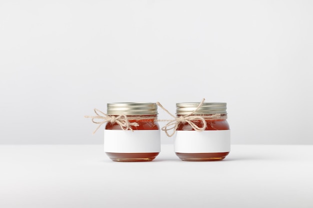 Photo two jars with honey twine and white label