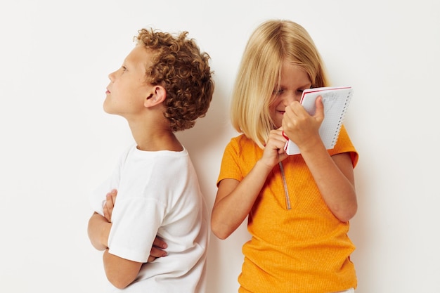 Two joyful children stand next to notepad pencil drawing emotions lifestyle unaltered