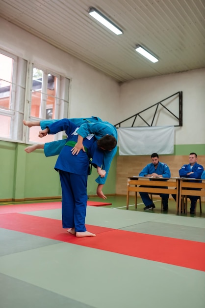 Two judo fighters showing technical skill while practicing martial arts in a fight club The two fit men in uniform fight karate training arts athlete competition conceptSelective Focus