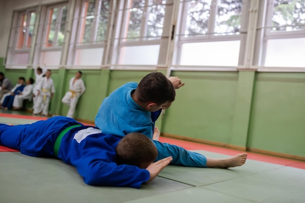 Two judo fighters showing technical skill while practicing martial arts in a fight club The two fit men in uniform fight karate training arts athlete competition conceptSelective Focus