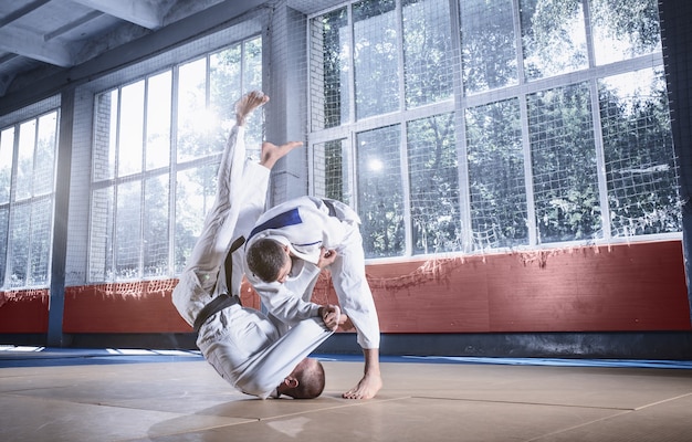 Two judo fighters showing technical skill while practicing martial arts in a fight club