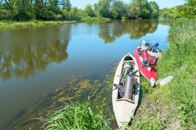 Due kayak in piedi in acqua vicino alla riva del fiume senza persone