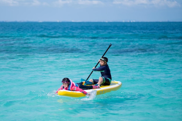 海でサーフィンをしている2人の子供