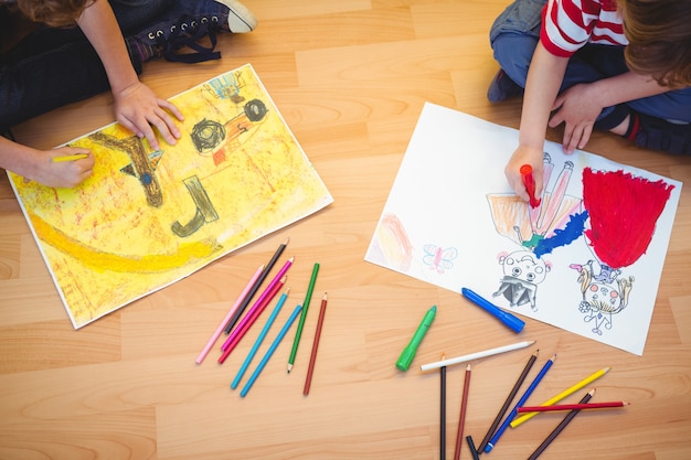 Two kids drawing together on sheets