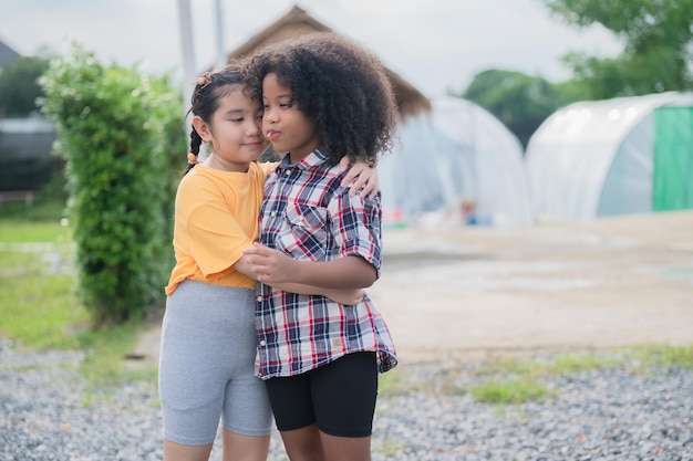 Two kids friends hugging outdoor having fun in summer