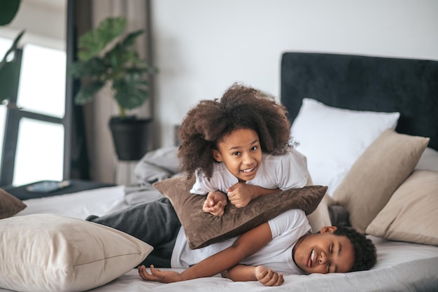 Two kids playing on the bed in the bedroom