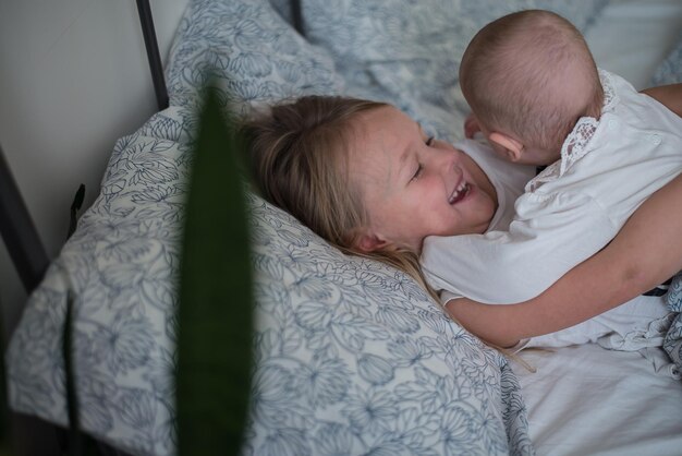 two kids playing in bed