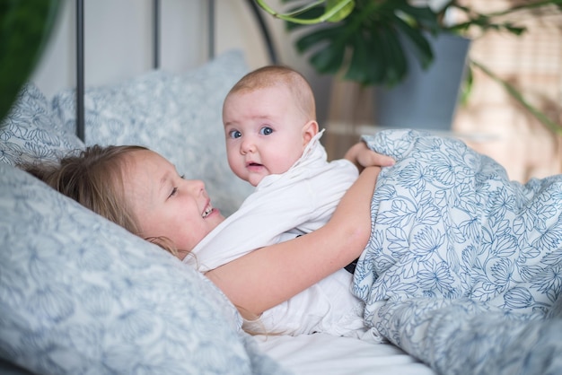 two kids playing in bed