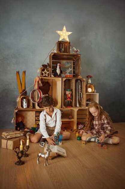 Двое детей играют дома во время зимних праздников
