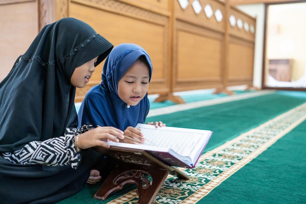 Photo two kids read holy quran