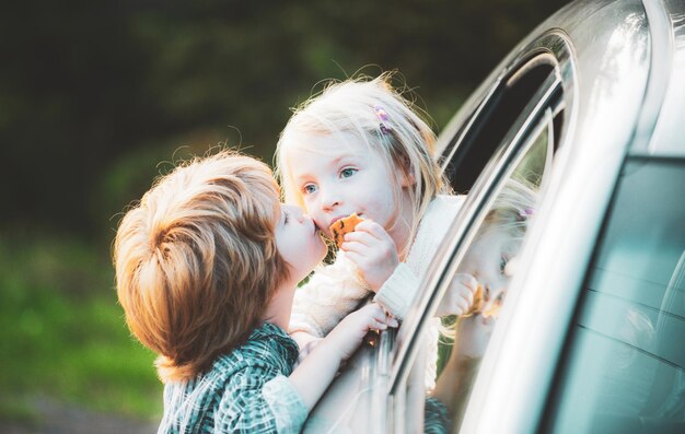 車の旅の前にさよならを言う2人の子供さようなら