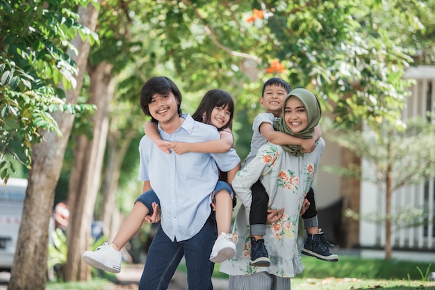 Two kids with their parent piggybackride