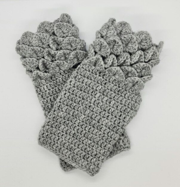 Two knitted mittens are laying on a white surface.